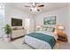 Cozy bedroom with ceiling fan, TV, and ensuite bathroom provides a relaxing space at 2027 Hayes Ln, Holly Springs, NC 27540
