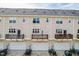 Exterior elevation of townhomes with garages and balconies at 2027 Hayes Ln, Holly Springs, NC 27540