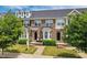 Charming brick townhome with well-maintained landscaping and inviting front porch at 2027 Hayes Ln, Holly Springs, NC 27540