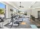 Well-equipped gym with treadmills, ellipticals, and weight machines next to bright windows with a view of the pool at 2027 Hayes Ln, Holly Springs, NC 27540
