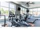 Well-lit fitness center with treadmills, elliptical machines, and large windows for natural light at 2027 Hayes Ln, Holly Springs, NC 27540
