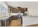 Well-appointed kitchen featuring dark wood cabinets, granite counters, and modern appliances at 2027 Hayes Ln, Holly Springs, NC 27540
