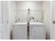 Bright laundry room with white washer and dryer and wire shelving at 2027 Hayes Ln, Holly Springs, NC 27540