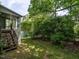 Landscaped backyard with a screened-in porch overlooking a scenic, tree-lined waterfront with fountain at 207 Reedhaven Dr, Cary, NC 27513