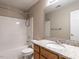 Bathroom features granite countertop, wooden cabinets, shower-tub combo, and vanity mirror at 207 Reedhaven Dr, Cary, NC 27513