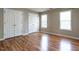 Spacious bedroom featuring hardwood floors, multiple closets, and bright windows at 207 Reedhaven Dr, Cary, NC 27513