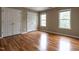 Bedroom with hardwood floors, two windows, and a double-door closet at 207 Reedhaven Dr, Cary, NC 27513