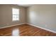 Neutral bedroom with hardwood floors, base trim, and a window offering natural light at 207 Reedhaven Dr, Cary, NC 27513