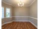Elegant dining room featuring hardwood floors, a stylish chandelier, and large windows for ample natural light at 207 Reedhaven Dr, Cary, NC 27513