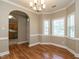 Bright dining area featuring hardwood floors, large windows, and an elegant chandelier. Open floorplan at 207 Reedhaven Dr, Cary, NC 27513