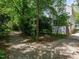 View of house exterior and driveway featuring mature trees providing ample shade for privacy at 207 Reedhaven Dr, Cary, NC 27513