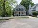 Charming two-story home featuring a white picket fence, covered porch, and landscaped yard with mature trees at 207 Reedhaven Dr, Cary, NC 27513