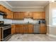 Well-lit kitchen featuring stainless steel appliances, tile flooring, and ample cabinet space with tile backsplash at 207 Reedhaven Dr, Cary, NC 27513