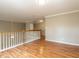 Spacious landing area with hardwood floors and decorative wooden railing at 207 Reedhaven Dr, Cary, NC 27513
