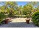 Private back yard with stone patio area surrounded by lush greenery at 212 Allister Dr, Raleigh, NC 27609