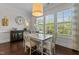 Bright dining room featuring a white dining set, modern lighting, and natural light from large windows at 212 Allister Dr, Raleigh, NC 27609