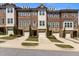 Townhome exterior with brick and stone accents, manicured lawns, driveways, and attached one car garages at 212 Allister Dr, Raleigh, NC 27609
