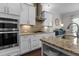 Well-lit kitchen with white cabinetry, stainless steel appliances, and speckled granite countertops at 212 Allister Dr, Raleigh, NC 27609