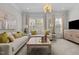 Bright living room featuring a plush sofa, stylish decor, and natural light from large windows at 212 Allister Dr, Raleigh, NC 27609
