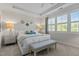 Bright main bedroom features large windows, tray ceiling, bench, and neutral decor at 212 Allister Dr, Raleigh, NC 27609