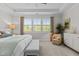 Spacious main bedroom featuring neutral decor, a comfortable chair, and large windows with blinds at 212 Allister Dr, Raleigh, NC 27609
