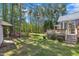 Expansive backyard featuring a wooden deck and lush green space surrounded by tall trees at 215 Oxfordshire Dr, Fuquay Varina, NC 27526