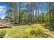 Spacious backyard features mature trees, green grass, storage shed and deck with stairs at 215 Oxfordshire Dr, Fuquay Varina, NC 27526