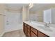 Bright bathroom showing tub/shower combo, double vanity with white counters and wood cabinets at 215 Oxfordshire Dr, Fuquay Varina, NC 27526