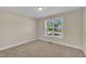 Carpeted bedroom features a window with blinds, natural light, and neutral paint at 215 Oxfordshire Dr, Fuquay Varina, NC 27526