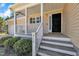 Charming front porch with white railings leading to a black front door and well-maintained landscaping at 215 Oxfordshire Dr, Fuquay Varina, NC 27526