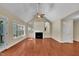 Bright living room featuring hardwood floors, fireplace, vaulted ceiling, and large windows at 215 Oxfordshire Dr, Fuquay Varina, NC 27526