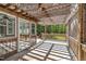 Covered porch featuring wood railings, lattice trim, and views of the wooded backyard at 215 Oxfordshire Dr, Fuquay Varina, NC 27526