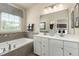 Modern bathroom with a double vanity, soaking tub, decorative tiles, and stylish fixtures at 2209 Pitchfork Ln, Durham, NC 27713