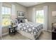 Inviting bedroom with a patterned comforter, bedside table, and bright natural light at 2303 Pitchfork Ln, Durham, NC 27713