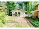 A charming outbuilding with a quaint garden and white picket fence offers additional space and curb appeal at 2307 Piedmont Dr, Sanford, NC 27330