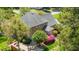 Aerial view showcasing a brick home's backyard patio and blooming landscape with trees at 2545 Churchill Dr, Burlington, NC 27215