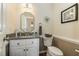 Charming powder room featuring a granite countertop, decorative mirror, and updated fixtures at 2545 Churchill Dr, Burlington, NC 27215