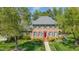 A beautifully landscaped brick house is framed by lush trees on a sunny day at 2545 Churchill Dr, Burlington, NC 27215