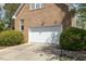 Attached two-car garage offers convenient parking and extra storage with lovely bushes nearby at 2545 Churchill Dr, Burlington, NC 27215