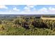 Expansive aerial view showcases the property's surrounding landscape, with dense forests and a clear blue sky at 2605 Joe Pruitt Rd, Oxford, NC 27565