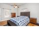 A cozy bedroom with hardwood floors, two windows, two dressers, and a bed with a blue and white blanket at 305 Freeman St, Raleigh, NC 27601