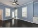 This bedroom features dark wood floors, blue walls, white trim, plantation shutters, and exterior door at 314 Gray Ave, Durham, NC 27701