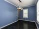 This dining room boasts dark wood floors, blue walls, white trim, and a modern light fixture at 314 Gray Ave, Durham, NC 27701