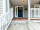 Charming home entrance with blue door, white trim, stone steps and wood porch provides curb appeal at 314 Gray Ave, Durham, NC 27701