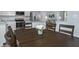 Open floor plan with a dining area featuring a wooden table and kitchen with stainless appliances at 338 Apricot Sun Way # 1196D, Zebulon, NC 27597