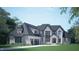 Elegant two-story home boasts a stone and siding facade, accented by a welcoming arched entry and three-car garage at 3608 Cobbler Vw Way, Fuquay Varina, NC 27526
