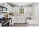 Modern kitchen featuring white cabinets, stainless steel appliances, and elegant countertops at 390 Hunting Wood Dr, Angier, NC 27501
