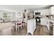 Bright kitchen with stainless appliances, an island, white cabinets, and an eat-in dining area with views to the living room at 390 Hunting Wood Dr, Angier, NC 27501