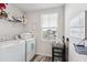 Functional laundry room with washer, dryer, shelving, and a view of the neighborhood at 390 Hunting Wood Dr, Angier, NC 27501