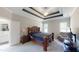 Primary bedroom featuring a tray ceiling, large bed, and lots of natural light at 395 Carolina Landing Dr, Zebulon, NC 27597